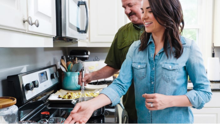 Whitney and John cooking a meal