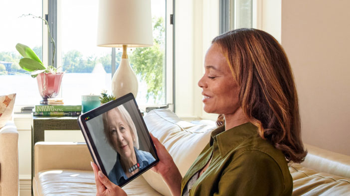 Courtney video chatting with a woman on a tablet