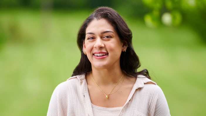 Woman standing outside smiling.