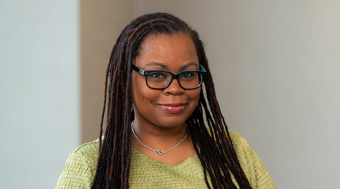 Black woman with long locs smiling