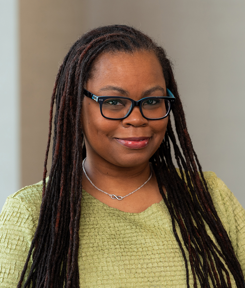 Black woman with long locs smiling