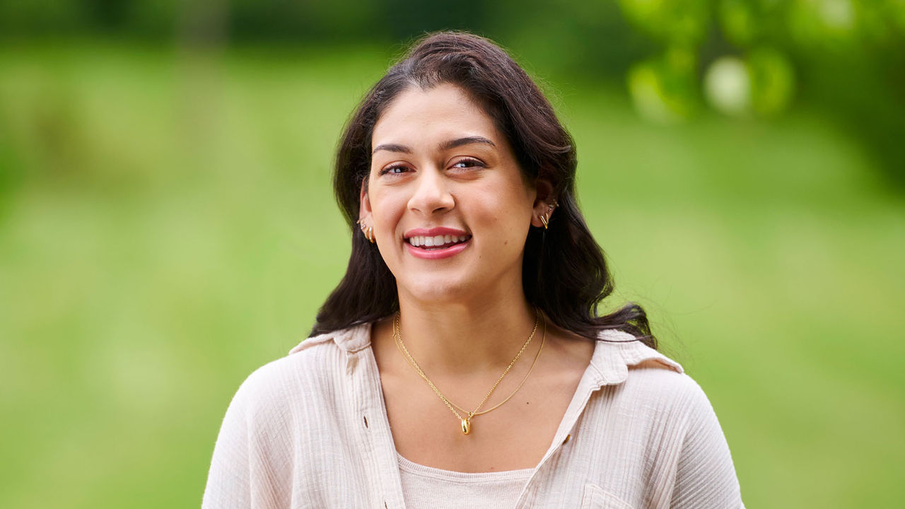 Woman standing outside smiling.