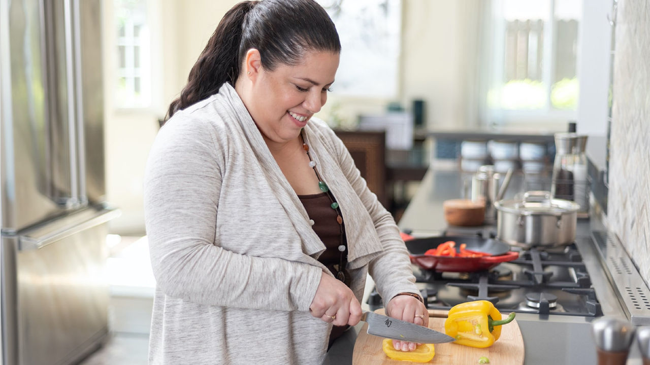 Leah chopping a bell pepper in the kitchen