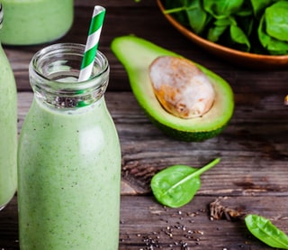 Green smoothie next to an avocado
